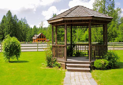 Beautifully manicured property with log house in background